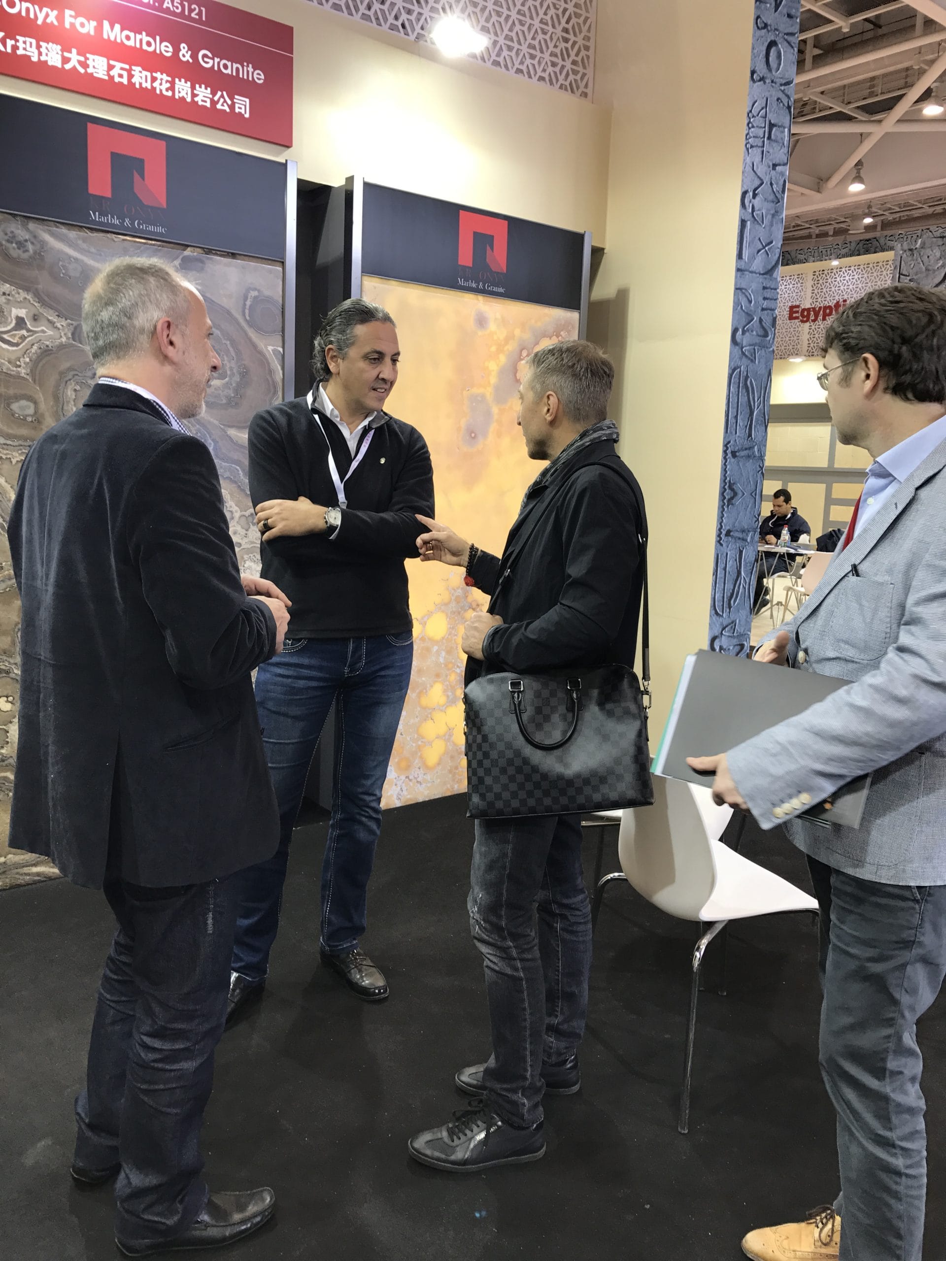 Marble staircase design consultation: Men discussing marble slab options for a custom-lit staircase project.