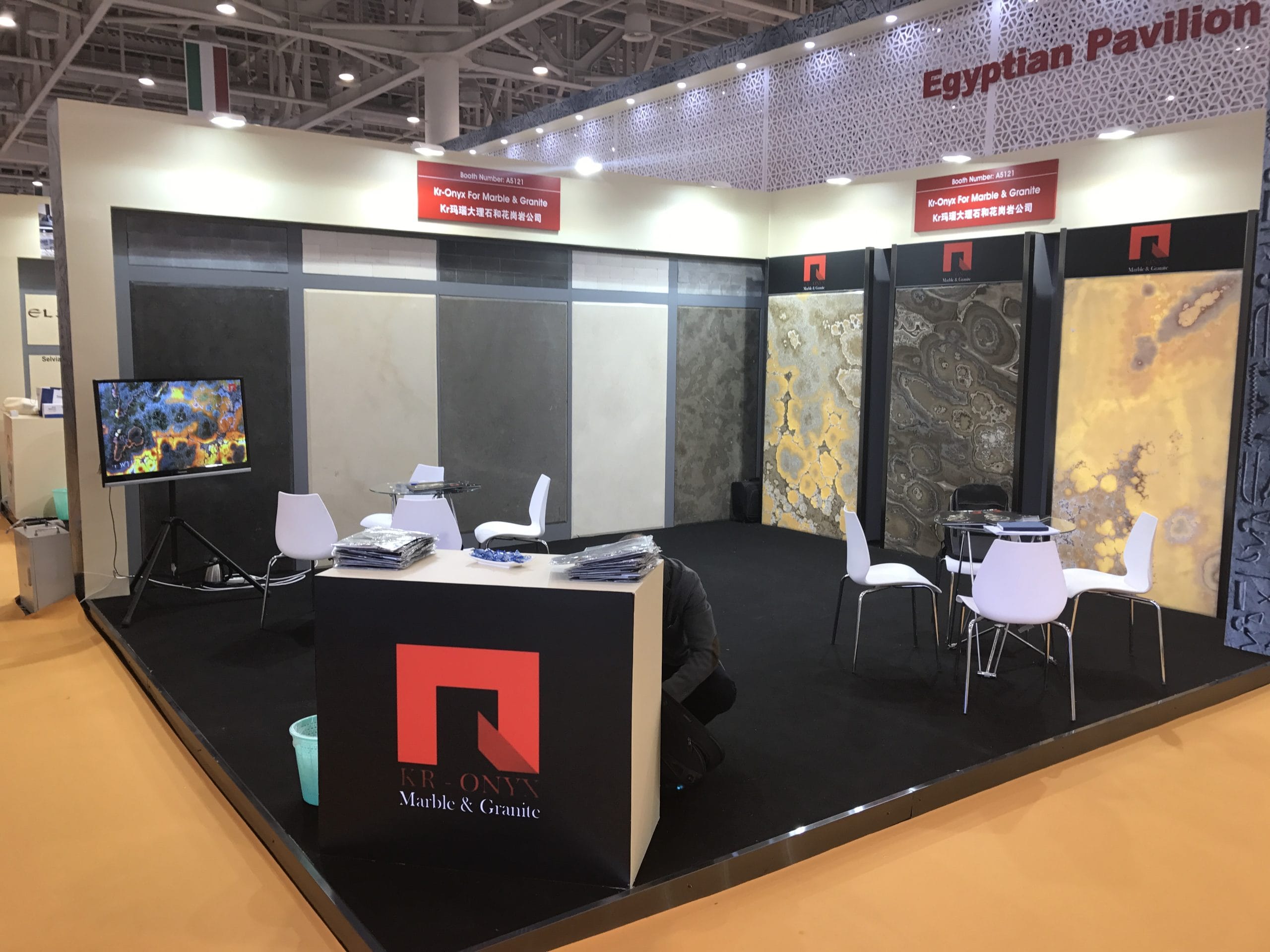 KR-Onyx Marble & Granite exhibit showcasing luxurious stone slabs at a global trade show. Features various colors and textures of marble and onyx.