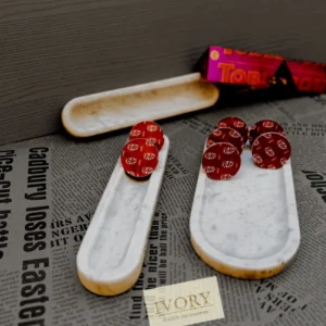 White marble trays holding chocolate candies; marble accessories.