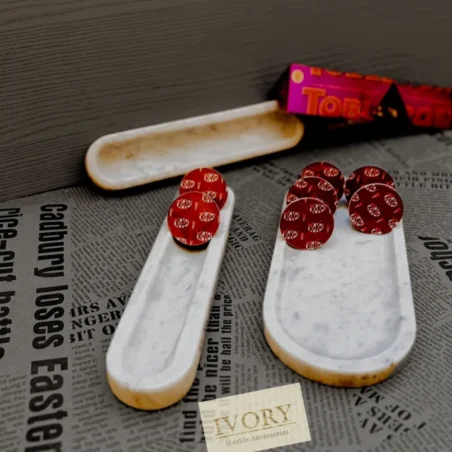 White marble trays holding chocolate candies; marble accessories.
