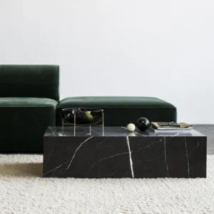 Black marble coffee table in a living room with a green velvet sofa