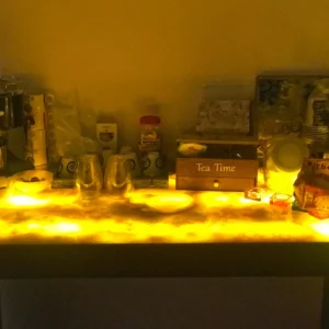 Illuminated onyx countertop with tea and coffee supplies, including a "Tea Time" box.
