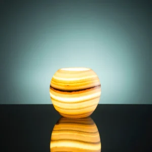 Illuminated alabaster sphere lamp on a dark surface