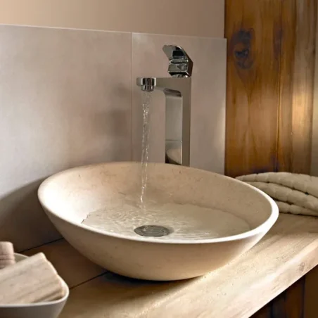 Modern oval stone sink with chrome faucet, ideal for contemporary bathrooms.