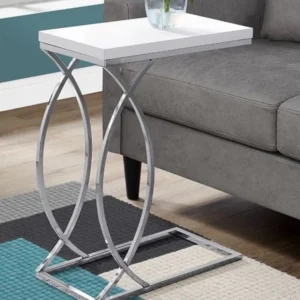 White end table with chrome legs next to gray couch