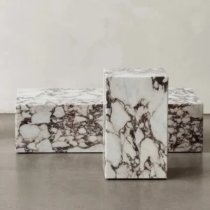 Three Calacatta Viola marble side tables; one tall, two low.