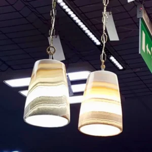 Two modern onyx pendant lights hang from chains against a grid ceiling.