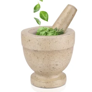 Beige marble mortar and pestle with fresh herbs