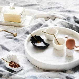 Marble serving tray with small bowls, spoons, salt, and a boiled egg.