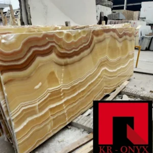 0008 Honey Onyx Marble Slab: Large slab of natural honey onyx stone featuring beautiful brown and beige wave patterns, ideal for countertops, backsplashes, or flooring.