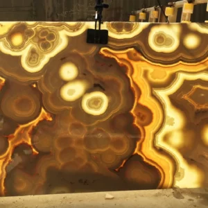 0007 Backlit Onyx Slab: Large, beautiful slab of natural onyx stone featuring swirling brown, gold, and beige patterns. Perfect for countertops or decorative features.