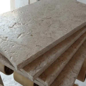 Stacked Marble Kathrin tiles, showcasing light beige color and textured surface. Perfect for flooring or wall cladding.