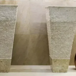 Pair of 031 textured marble pedestal sinks with beige bases. Elegant bathroom sinks for modern design.