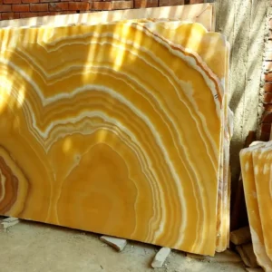 00018 Yellow Onyx Marble Slabs: Natural stone slabs featuring beautiful swirling patterns in shades of yellow and orange.