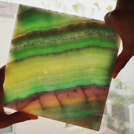 0040: Stunning layered fluorite gemstone slab with vibrant green, yellow, and purple hues. Translucent mineral specimen.